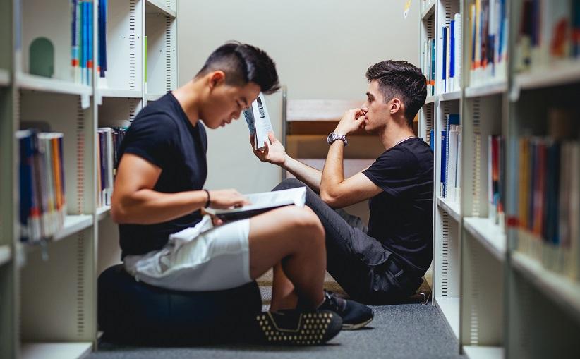 Zdjęcie przedstawia studentów w bibliotece.