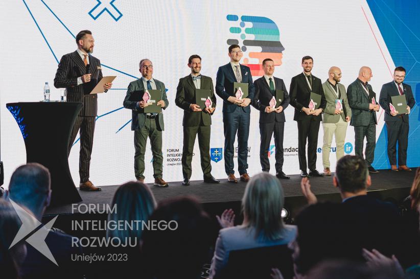 Zdjęcie przedstawia laureatów nagrody, którzy pozują na scenie do wspólnego zdjęcia. Zdjęcie przedstawia laureatów nagrody, którzy pozują na scenie do wspólnego zdjęcia.