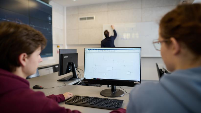 Dwie osoby, które patrzą na monitor komputera.